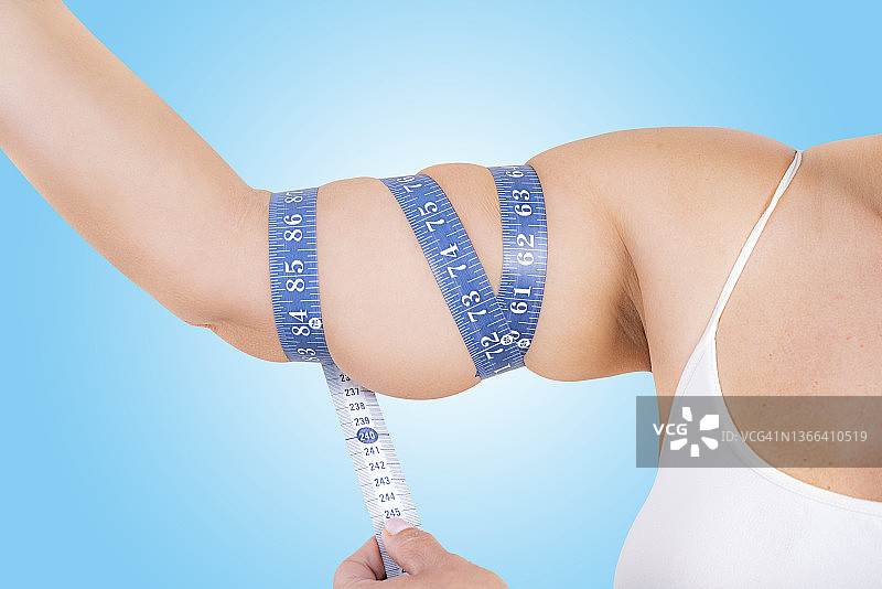 用卷尺测量妇女手臂上的脂肪组织图片素材