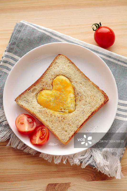 早餐是烤面包和心形煎蛋。情人节贺卡。图片素材