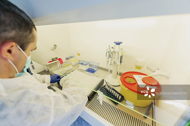 新冠病毒Omicron突变。、实验室研究。离心式PCR研究设备、防护口罩、眼镜和防护服一套图片素材