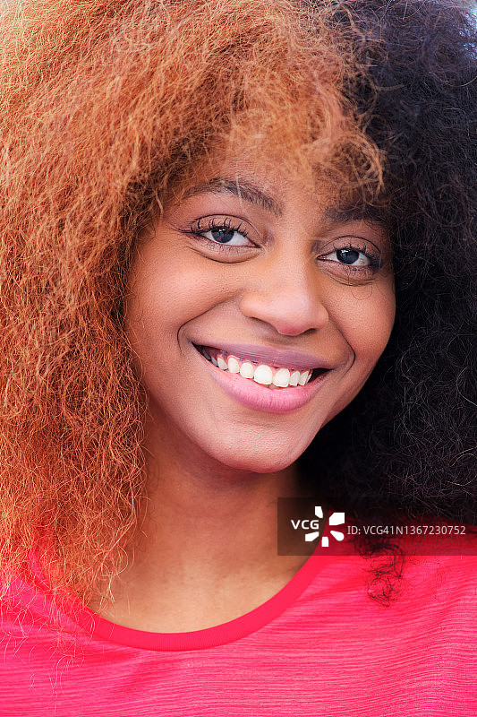 年轻的黑人女士，一头非洲式的头发，对着镜头微笑图片素材