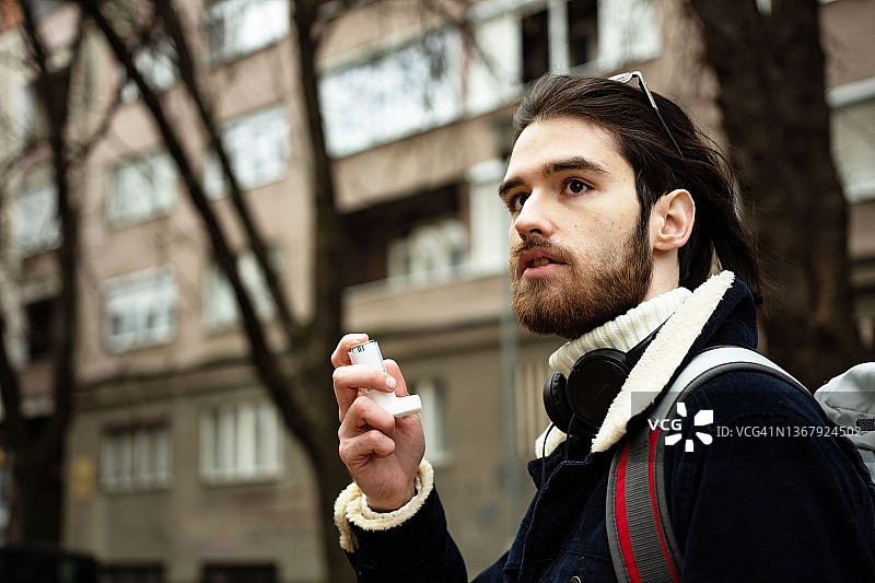 男子使用哮喘吸入器图片素材