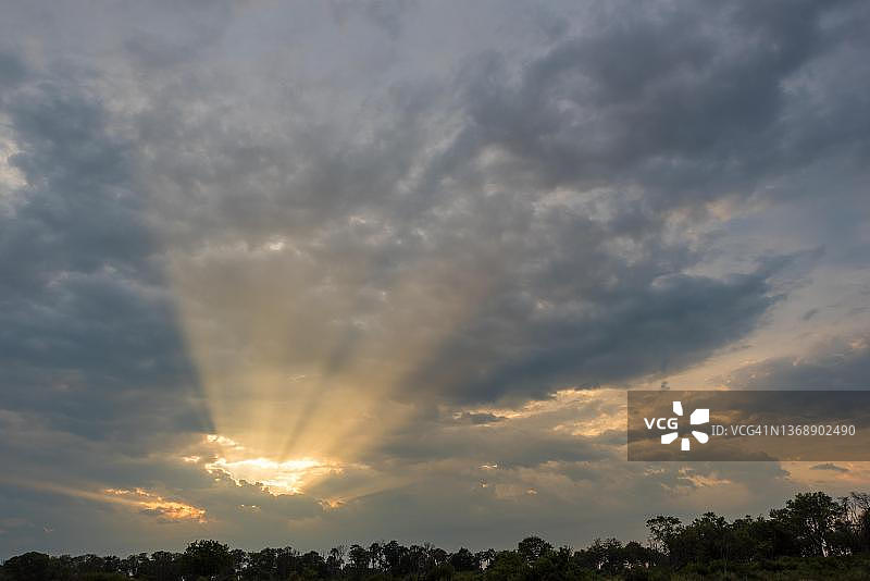 阳光穿过云层，奥卡万戈三角洲，图布树营，博茨瓦纳图片素材