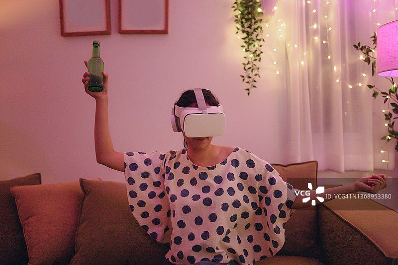 年轻女子戴着VR头盔玩游戏，在虚拟现实世界中享受乐趣图片素材