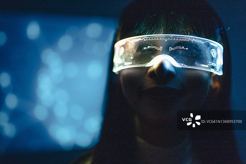 一名年轻女子戴着带有高科技背景的未来派眼镜图片素材