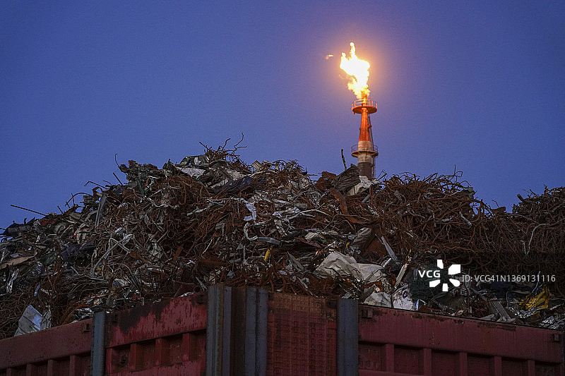 一堆废金属后面燃烧的火焰图片素材