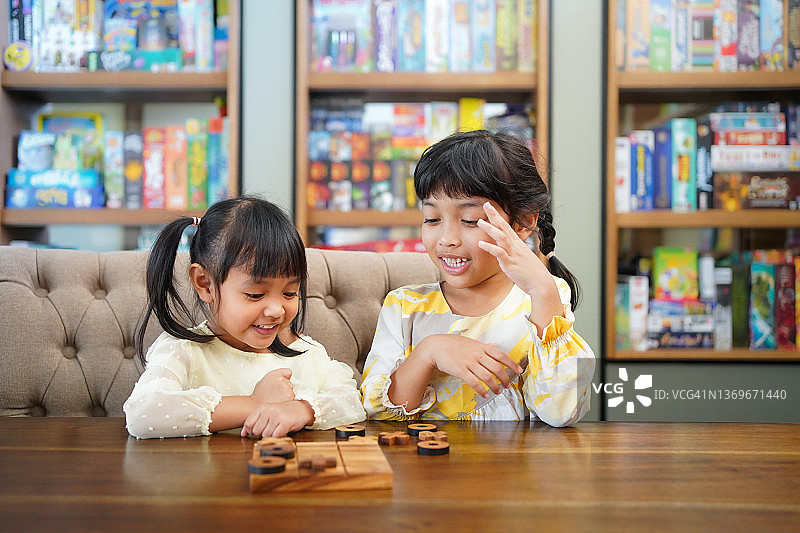 亚洲儿童在家里玩棋盘游戏。图片素材
