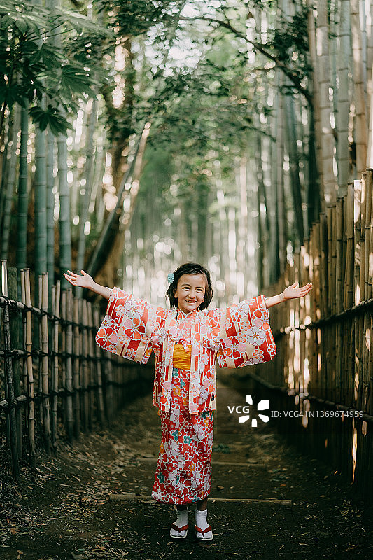 在日本竹林里，一个穿着和服的快乐女孩图片素材