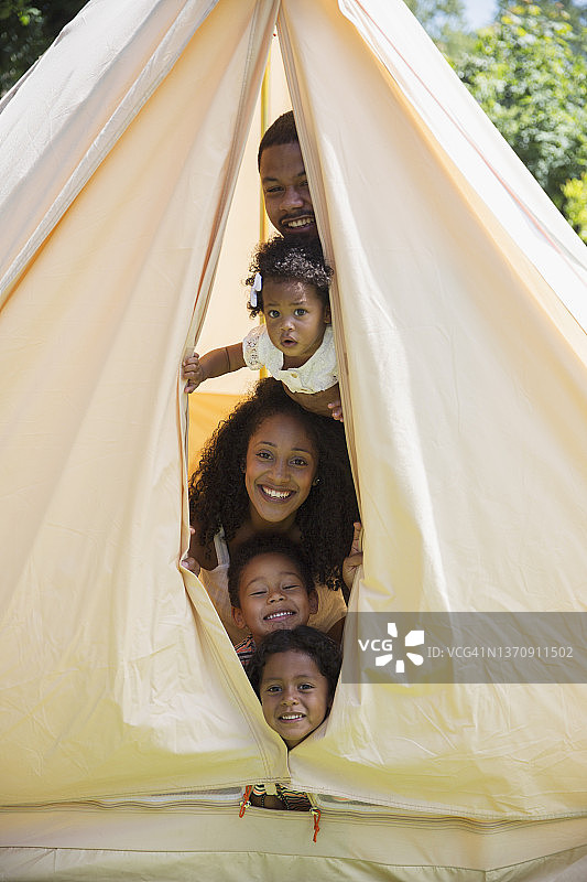 有趣的一家人从帐篷里窥视的肖像图片素材