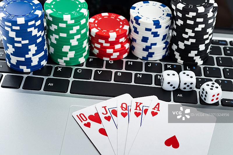 赌博筹码和扑克牌在笔记本电脑键盘上图片素材