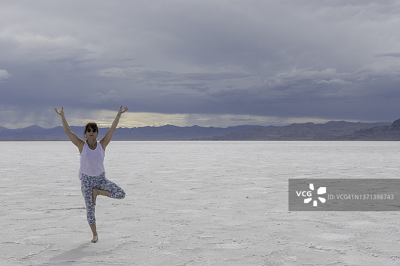 一名女子在犹他州的博纳维尔盐滩练习瑜伽图片素材