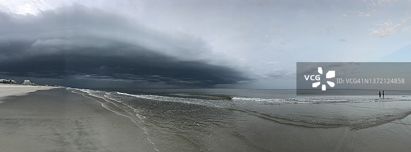 广角视角的黑暗和不祥的风暴在海滩上图片素材