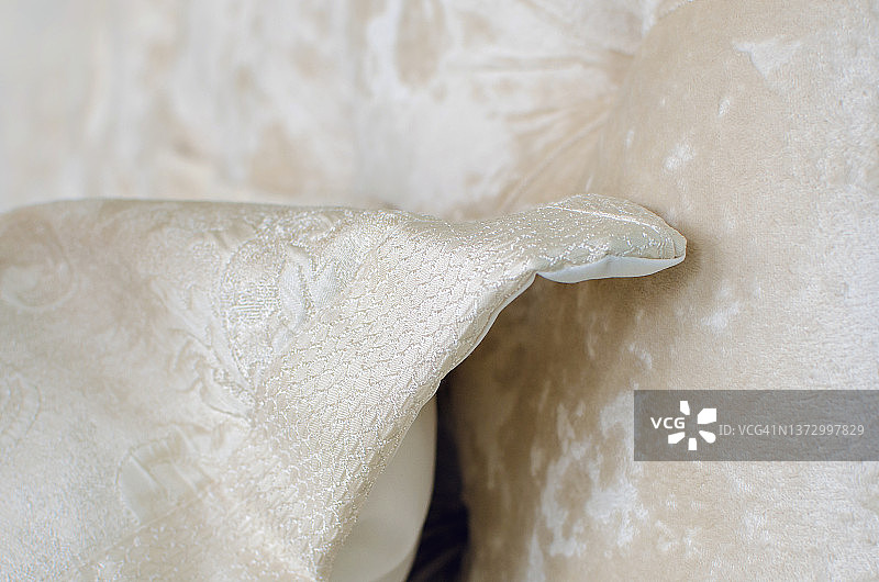一个由缎子织物制成的枕头的特写细节。昂贵的别致的室内。图片素材