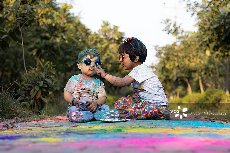 快乐的亚洲印度孩子男孩和女孩享受节日的颜色与胡里彩粉称为古拉尔图片素材
