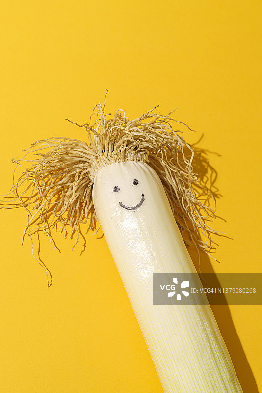 黄色背景上画脸的快乐韭菜图片素材