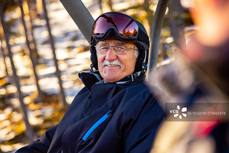 图为白人老人和女儿在滑雪胜地乘坐缆车时的情景图片素材