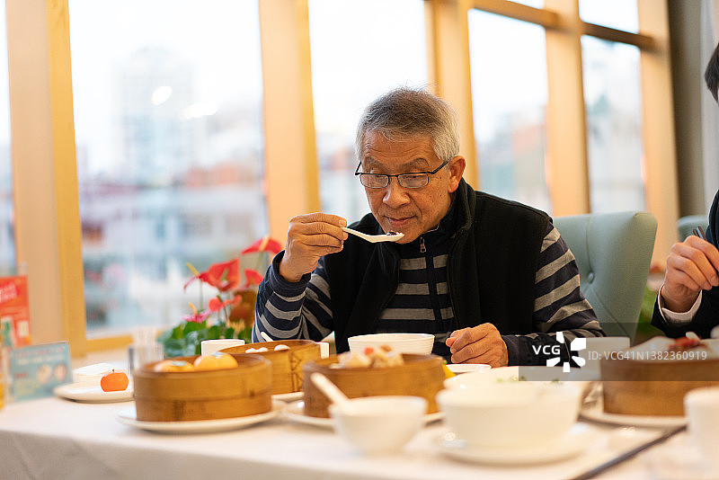 一名亚洲男子正在享受广东菜图片素材