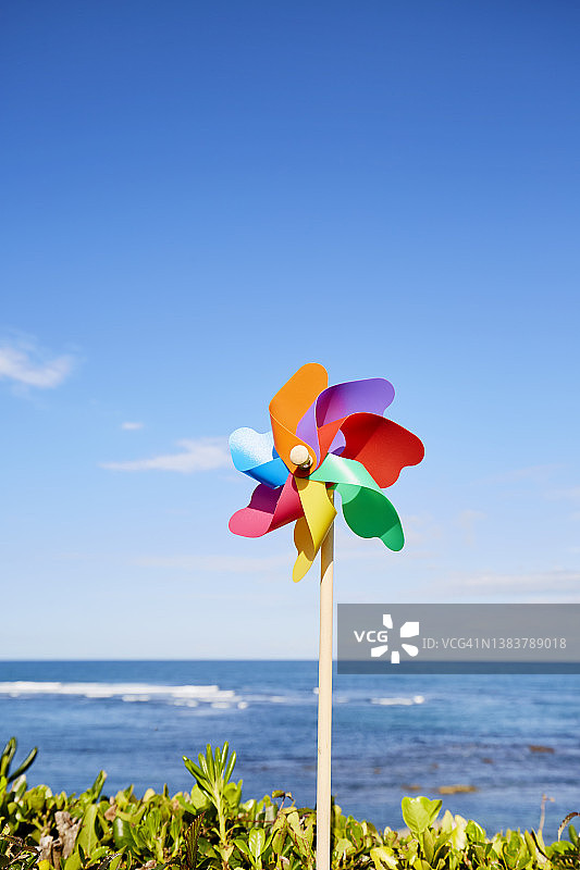 五颜六色的风车映衬着大海和蓝天图片素材