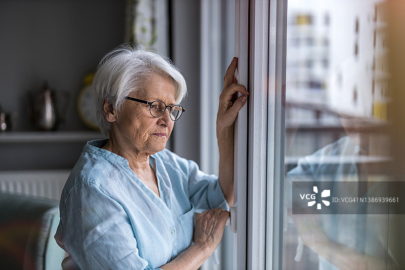 老妇人在家看着窗外图片素材