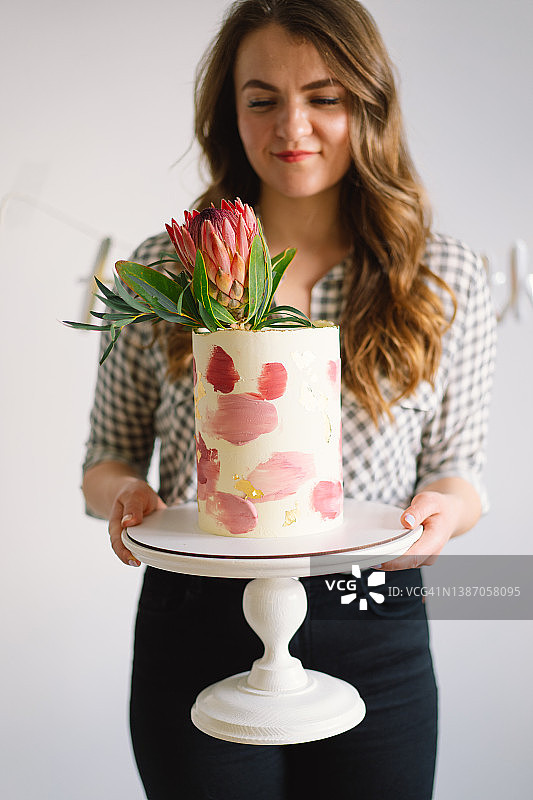 拿着生日蛋糕的年轻女人，靠近点。图片素材