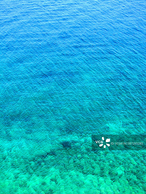 高角度看平静的海水。蓝色、天蓝色、绿松石色。图片素材