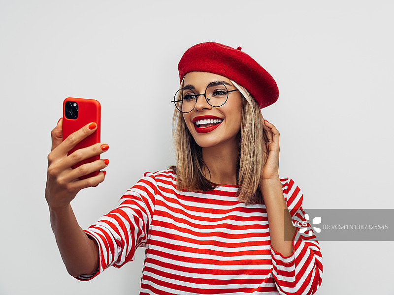 性感的法国女人戴着红色贝雷帽和自拍图片素材
