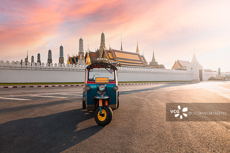 嘟嘟车停在泰国曼谷的Wat Phra Kaeo或大皇宫前。这是黄昏天空下宫殿的美丽景色。图片素材