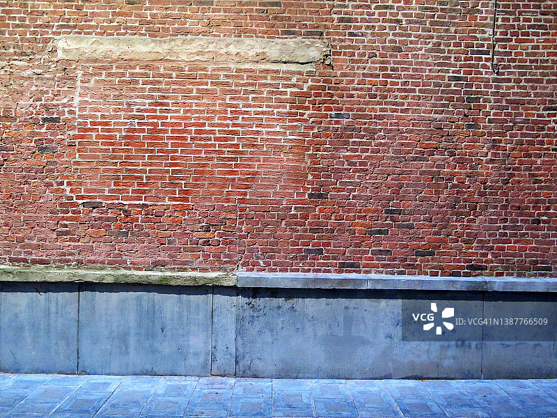 饱经风霜的砖和灰色石墙与人行道在城市照明下的布鲁塞尔图片素材