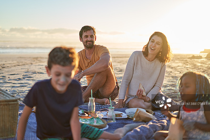 幸福的家庭享受野餐在阳光明媚的海滩图片素材