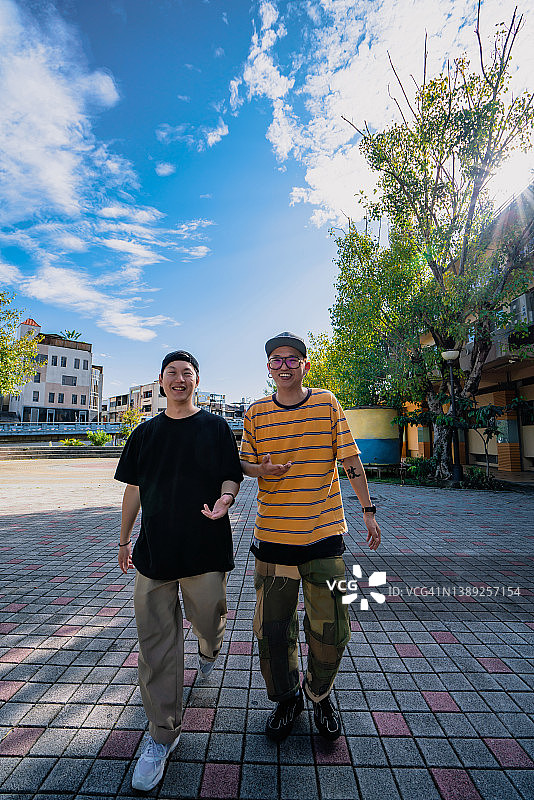 两个亚洲老年男子走在街上，充满信心。图片素材