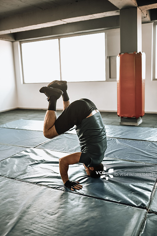 男性在健身房做体操头倒立运动图片素材