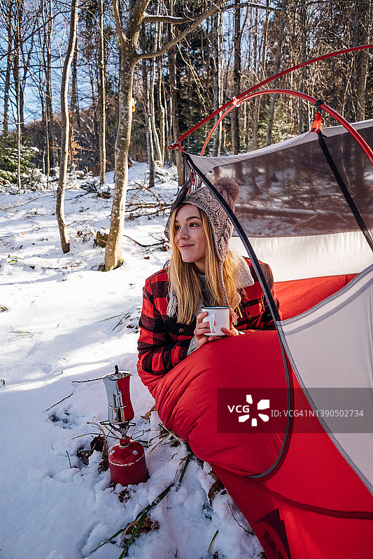 帐篷里穿红色睡袋的女人微笑着图片素材