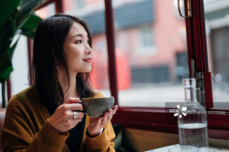 年轻女子在咖啡馆享受咖啡休息时间图片素材