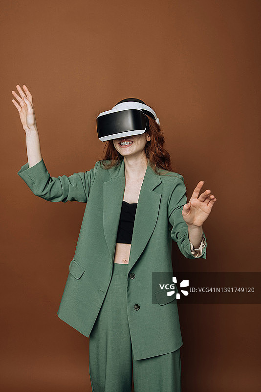 戴着虚拟现实眼镜的快乐女人使用科技玩游戏。虚拟现实开发概念图片素材