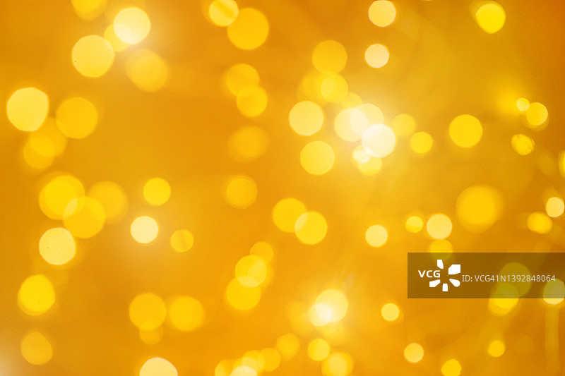 节日黄金圣诞背景制成的发光散焦花环与许多灯。庆祝新年的概念图片素材