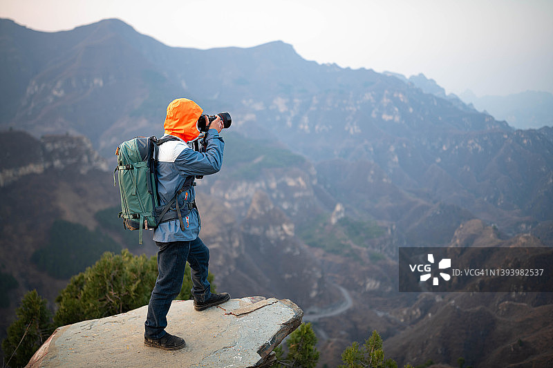 摄影师在山顶上拍摄了远处的群山图片素材