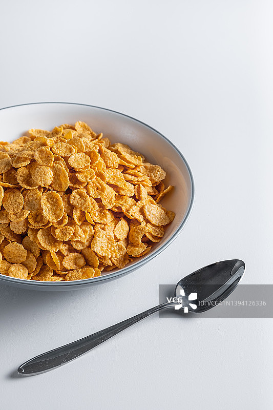 晾干的蜂蜜玉米片可以放在家里餐桌上的陶瓷盘子里，也可以放在白色背景上。俯视图，复制空间。健康饮食的概念，素食和纯素食的早餐。图片素材