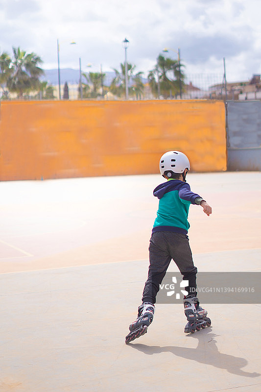 男孩在溜冰场练习单排滑冰。图片素材