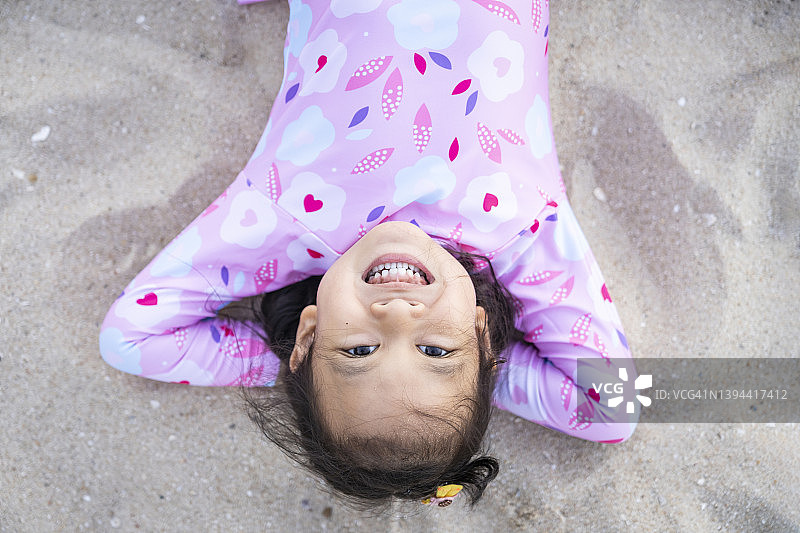 小女孩躺在沙滩上图片素材