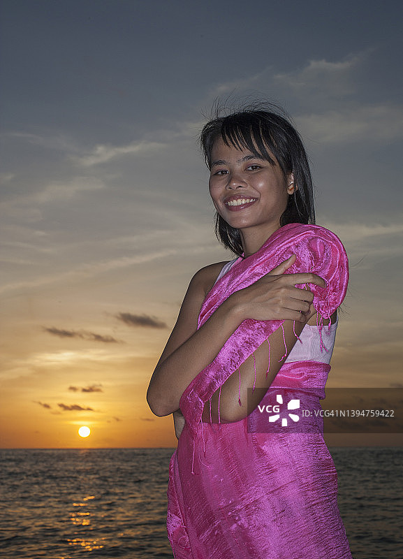 热带海滩上的年轻女子。图片素材