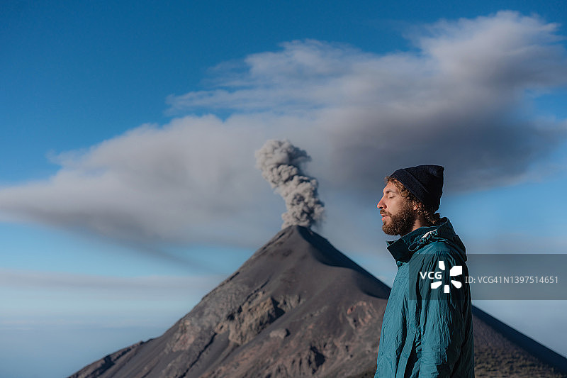 一名男子站在危地马拉富埃戈火山爆发的背景上图片素材