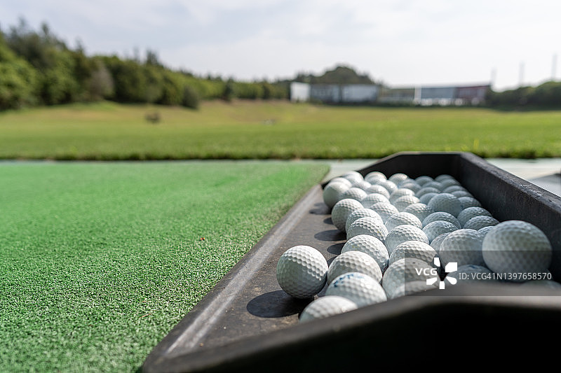 高尔夫球场绿地上的黑色盘子里放着高尔夫球图片素材