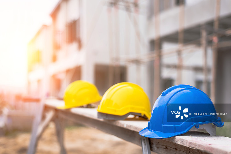 安全建筑工人帽子蓝色，白色，黄色，橙色。施工团队的团队合作必须有质量。无论是工程师，建筑工人。工作时要戴头盔。图片素材