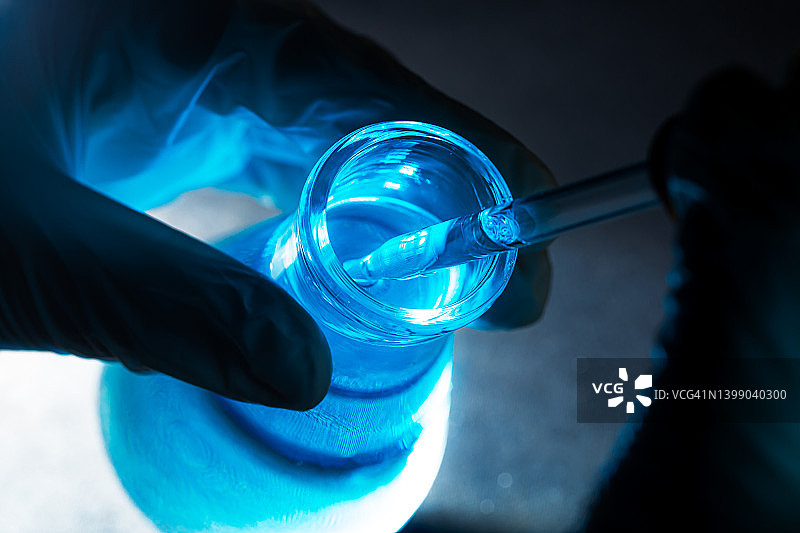 蓝色科学实验玻璃管，研究人员在液体玻璃实验室用化学试管进行分析，医学，制药和科学研究概念图片素材