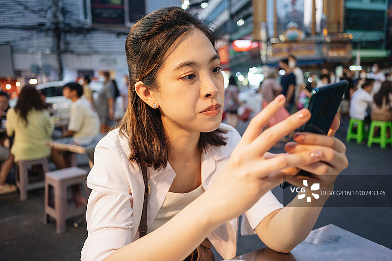 美食爱好者甜食爱好者年轻的亚洲当地游客开心地在社交媒体上分享在泰国曼谷的唐人街吃街头小吃的时刻图片素材