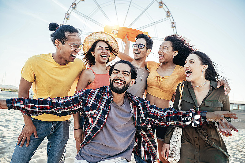 多种族的朋友群在夏季假期的海滩派对-愉快的年轻人有乐趣一起挂在外面的阳光灿烂的一天-暑假和友谊的概念图片素材