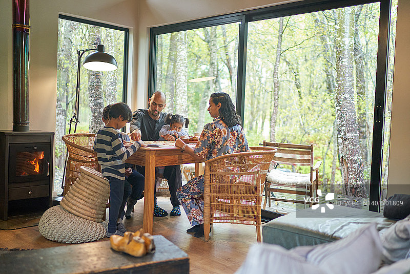 一家人在树林里的小木屋桌上玩游戏图片素材