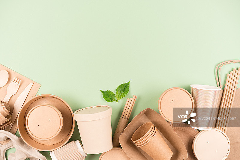 生态纸器皿和木制竹制餐具，食品容器和纸杯在浅绿色的背景上的复制空间。可持续食品包装理念图片素材