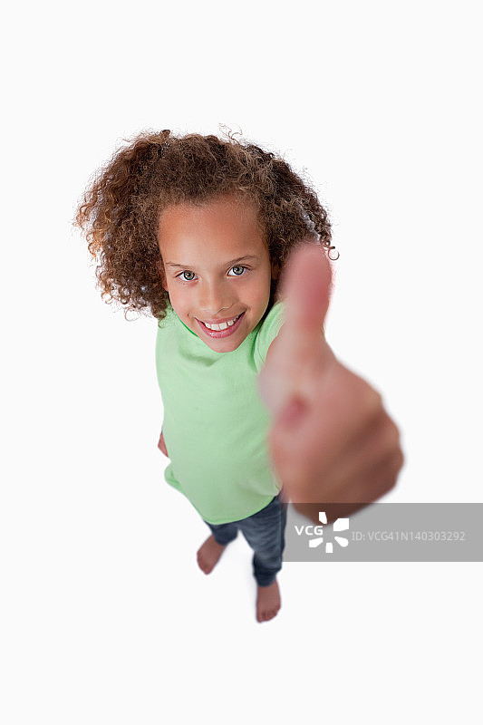 一个微笑着竖起大拇指的女孩的肖像图片素材