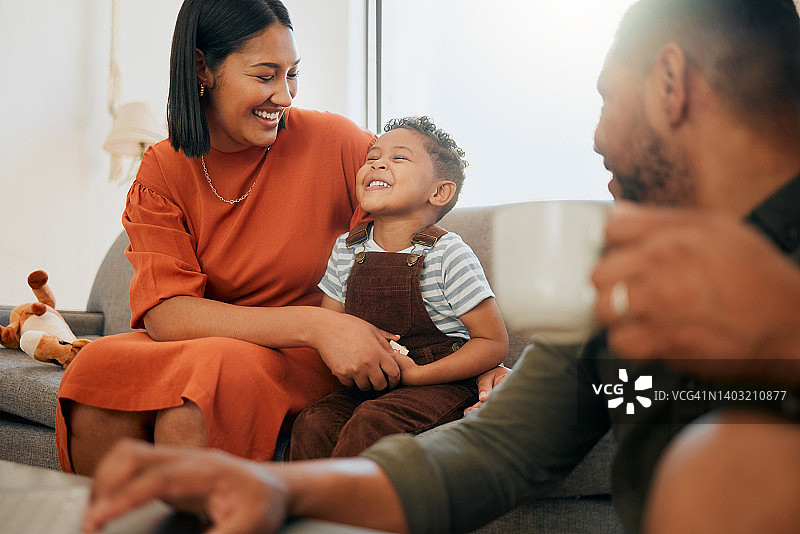 一个幸福的混血三口之家在休息室放松，一起玩耍。爱黑人家庭和他们的儿子在家里的沙发上玩有趣的游戏图片素材