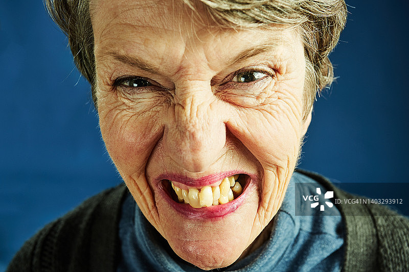一位老妇人露出牙齿看着镜头图片素材